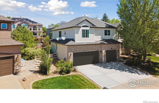 3931 Stonegrass Pt, Broomfield, CO 80023 - traditional home featuring driveway, a garage, roof with shingles, a gate, and brick siding
