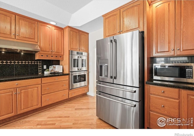 5753 Secrest Ct, Golden, CO 80403 - kitchen featuring appliances with stainless steel finishes, under cabinet range hood, backsplash, light wood-style flooring, and brown cabinetry