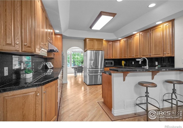 5753 Secrest Ct, Golden, CO 80403 - kitchen featuring stainless steel appliances, a peninsula, decorative backsplash, arched walkways, and recessed lighting