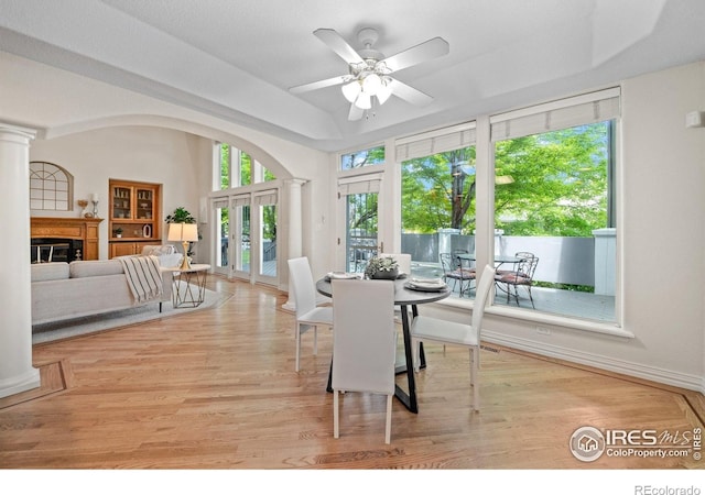 5753 Secrest Ct, Golden, CO 80403 - dining room featuring decorative columns, a glass covered fireplace, ceiling fan, wood finished floors, and french doors