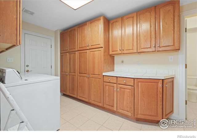 5753 Secrest Ct, Golden, CO 80403 - laundry room with cabinet space, separate washer and dryer, and light tile patterned flooring