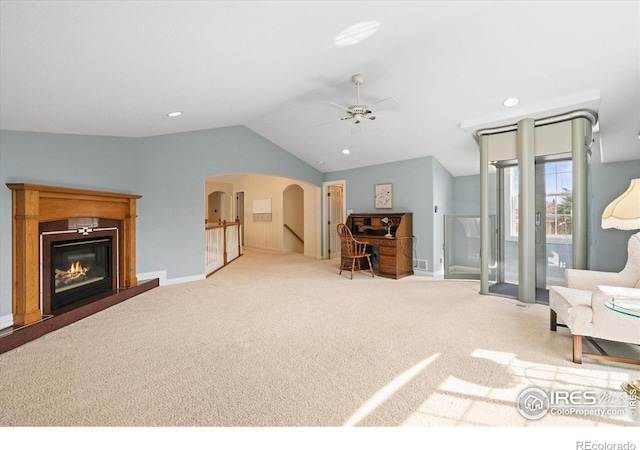 5753 Secrest Ct, Golden, CO 80403 - living room featuring carpet, vaulted ceiling, ceiling fan, arched walkways, and a glass covered fireplace