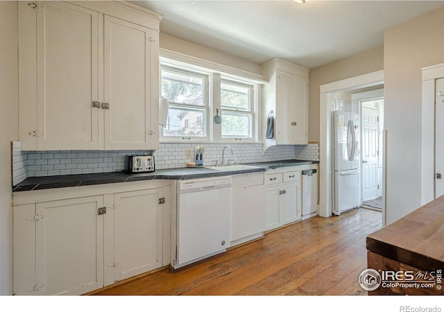 1421 N 7th St, Grand Junction, CO 81501 - kitchen featuring white appliances, tasteful backsplash, light wood-style flooring, and white cabinets
