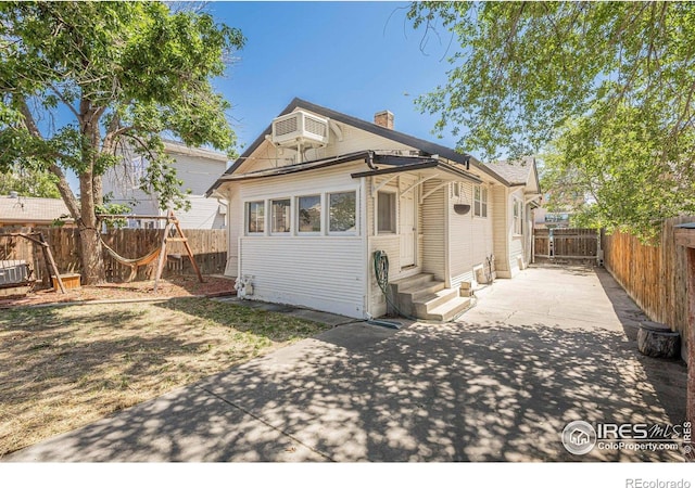 1421 N 7th St, Grand Junction, CO 81501 - view of front of property featuring entry steps, a patio area, a fenced backyard, a chimney, and a wall mounted AC
