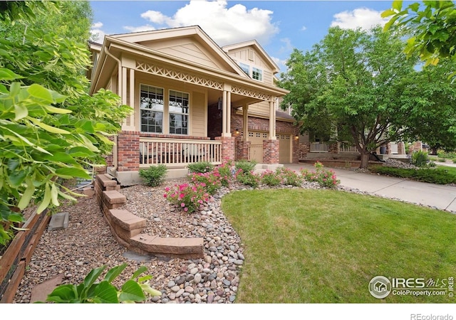 13266 Teller Lake Way, Broomfield, CO 80020 - view of front facade with a porch, driveway, brick siding, a front lawn, and an attached garage