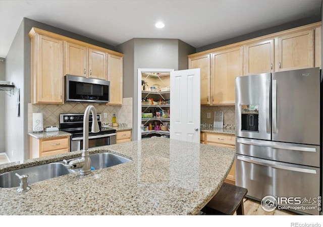 13266 Teller Lake Way, Broomfield, CO 80020 - kitchen featuring stainless steel appliances, light brown cabinets, light stone countertops, tasteful backsplash, and recessed lighting