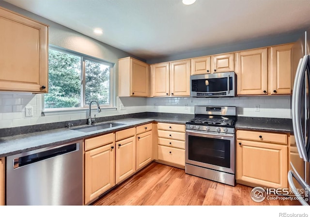 1616 Cedarwood Dr, Longmont, CO 80504 - kitchen featuring stainless steel appliances, light brown cabinetry, light wood-type flooring, dark countertops, and recessed lighting