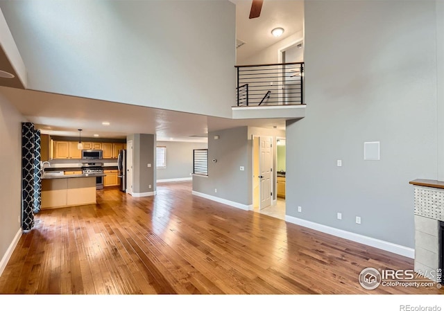 1616 Cedarwood Dr, Longmont, CO 80504 - unfurnished living room featuring light wood-style flooring and a high ceiling