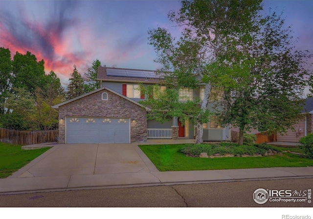 1616 Cedarwood Dr, Longmont, CO 80504 - view of front of house featuring stone siding, driveway, roof mounted solar panels, and a garage