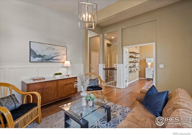 2833 Annelise Way, Fort Collins, CO 80525 - living room with a chandelier, wood finished floors, a decorative wall, and wainscoting