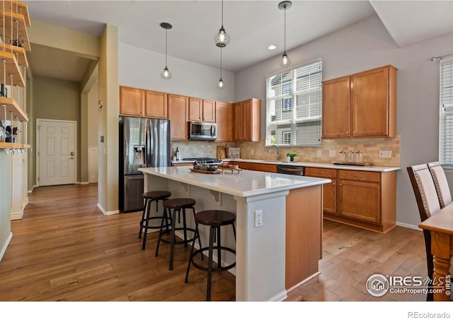 2833 Annelise Way, Fort Collins, CO 80525 - kitchen with appliances with stainless steel finishes, decorative backsplash, light wood-type flooring, light countertops, and recessed lighting