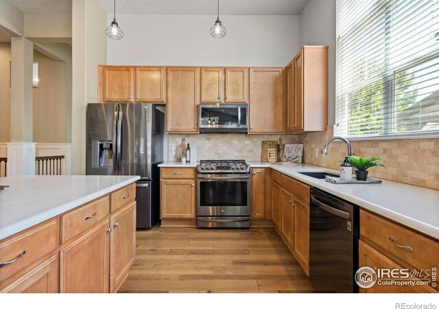 2833 Annelise Way, Fort Collins, CO 80525 - kitchen featuring appliances with stainless steel finishes, light wood finished floors, light countertops, and decorative backsplash