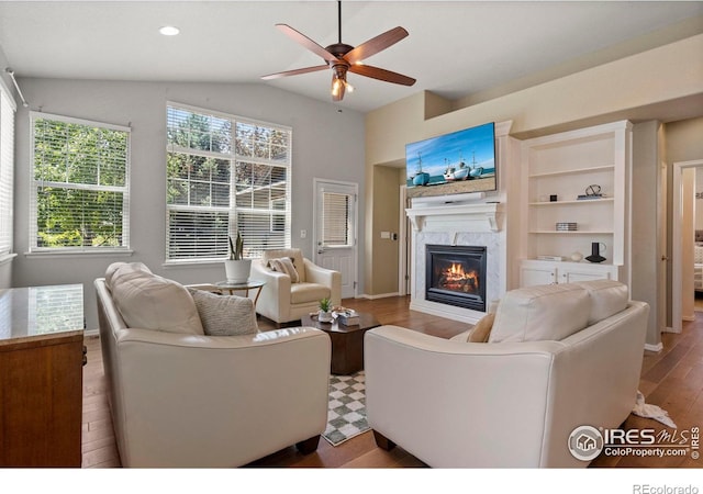 2833 Annelise Way, Fort Collins, CO 80525 - living area with a glass covered fireplace, a ceiling fan, wood finished floors, and lofted ceiling