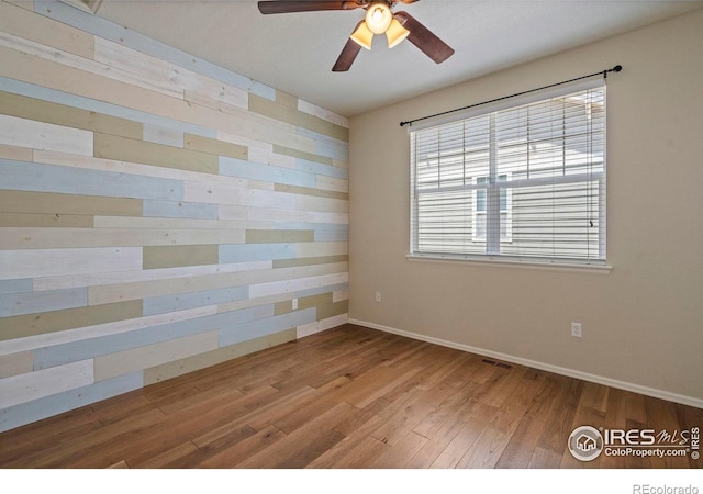 2833 Annelise Way, Fort Collins, CO 80525 - unfurnished room with ceiling fan, wood finished floors, and wood walls