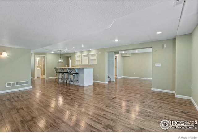 2833 Annelise Way, Fort Collins, CO 80525 - unfurnished living room featuring wood finished floors, a textured ceiling, and recessed lighting
