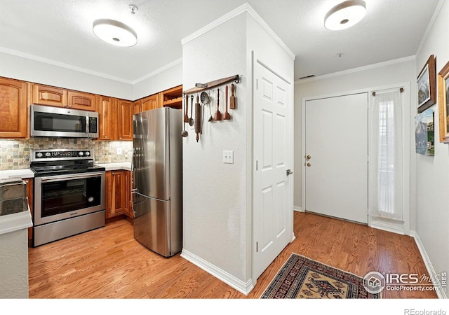 854 Walnut St Unit B, Boulder, CO 80302 - kitchen with stainless steel appliances, brown cabinetry, light wood-type flooring, backsplash, and ornamental molding