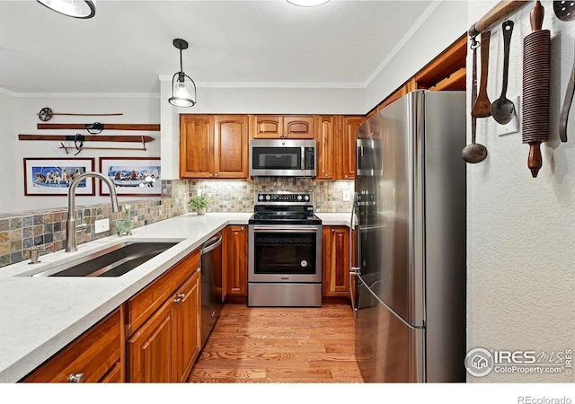 854 Walnut St Unit B, Boulder, CO 80302 - kitchen featuring appliances with stainless steel finishes, brown cabinetry, light wood-type flooring, backsplash, and crown molding