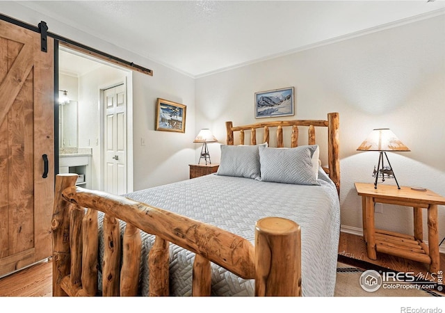 854 Walnut St Unit B, Boulder, CO 80302 - bedroom with a barn door, light wood-style flooring, crown molding, and ensuite bath