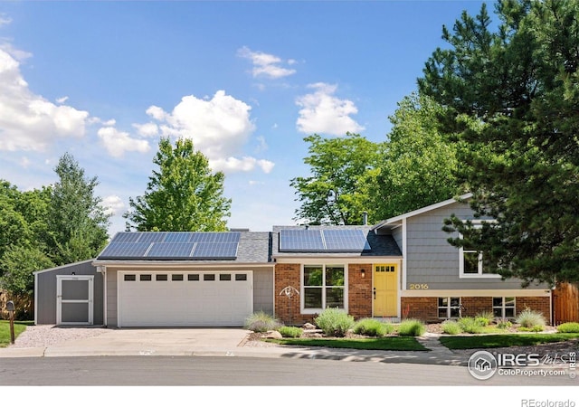 2016 Strathmore St, Louisville, CO 80027 - view of front facade with an attached garage, driveway, roof mounted solar panels, and brick siding