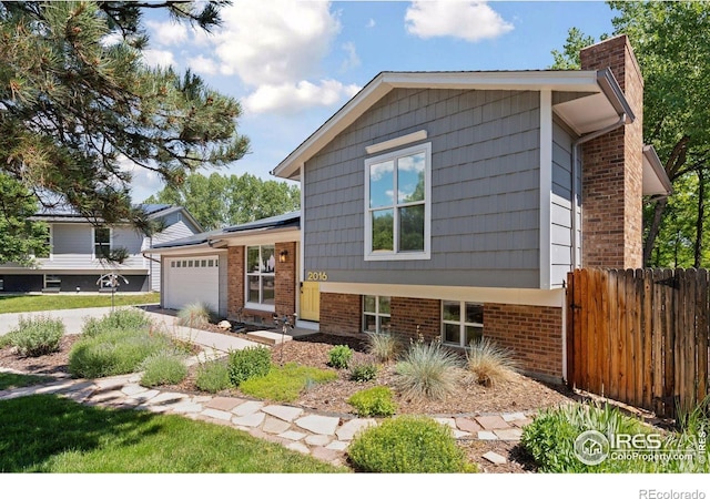 2016 Strathmore St, Louisville, CO 80027 - split level home with an attached garage, a chimney, and brick siding