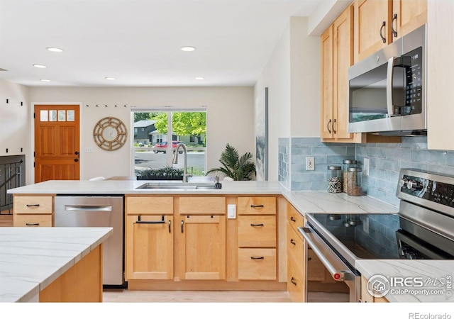 2016 Strathmore St, Louisville, CO 80027 - kitchen with appliances with stainless steel finishes, a peninsula, light stone counters, light brown cabinetry, and recessed lighting