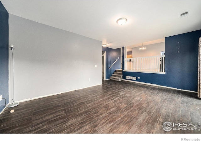 9673 Roadrunner Ave, Firestone, CO 80504 - empty room with wood finished floors, stairway, and a chandelier