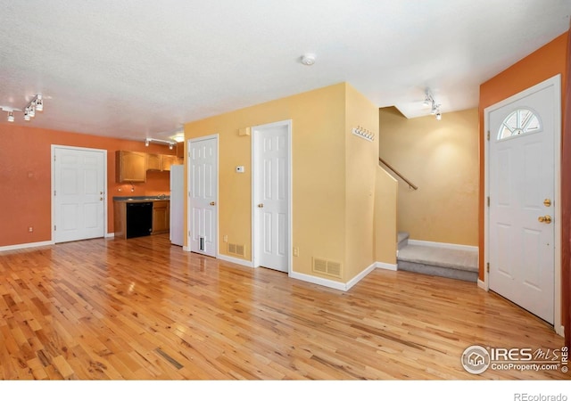 3350 Saratoga St Unit C, Wellington, CO 80549 - unfurnished living room featuring track lighting, light wood-style floors, and stairway