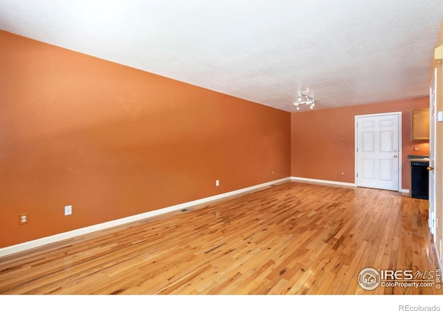 3350 Saratoga St Unit C, Wellington, CO 80549 - spare room with light wood-type flooring, track lighting, and a textured ceiling