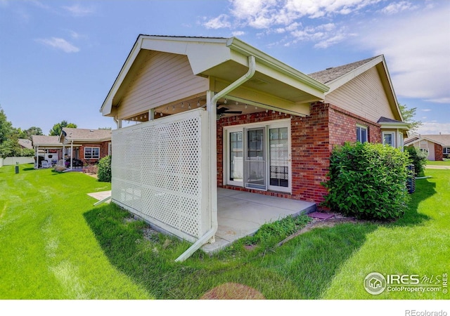 1250 Honeysuckle Ct, Windsor, CO 80550 - view of home's exterior featuring brick siding, a lawn, a patio, and ceiling fan