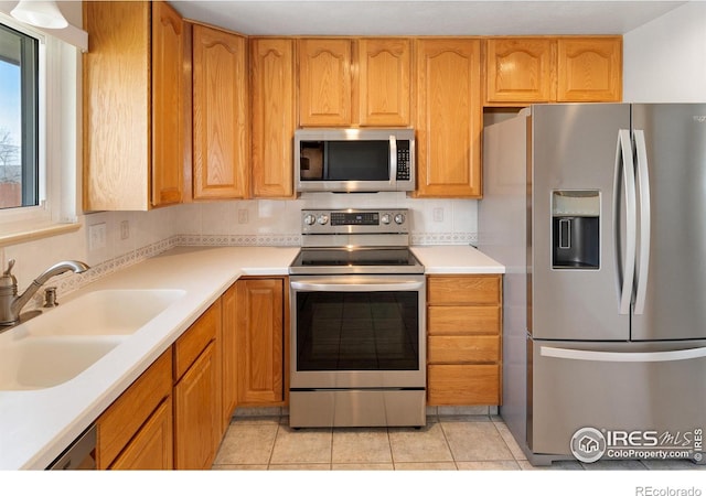 7162 Quay St, Arvada, CO 80003 - kitchen with stainless steel appliances, light tile patterned floors, and light countertops