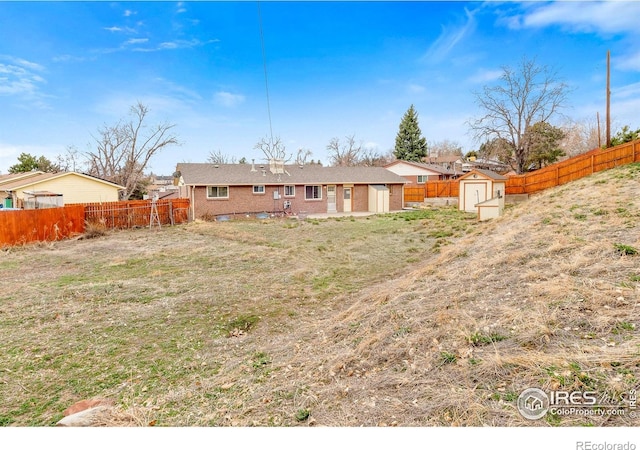 7162 Quay St, Arvada, CO 80003 - rear view of house with a storage shed, a fenced backyard, and brick siding