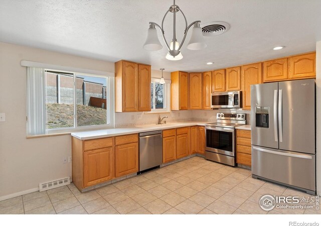 7162 Quay St, Arvada, CO 80003 - kitchen with appliances with stainless steel finishes, plenty of natural light, light countertops, a chandelier, and recessed lighting