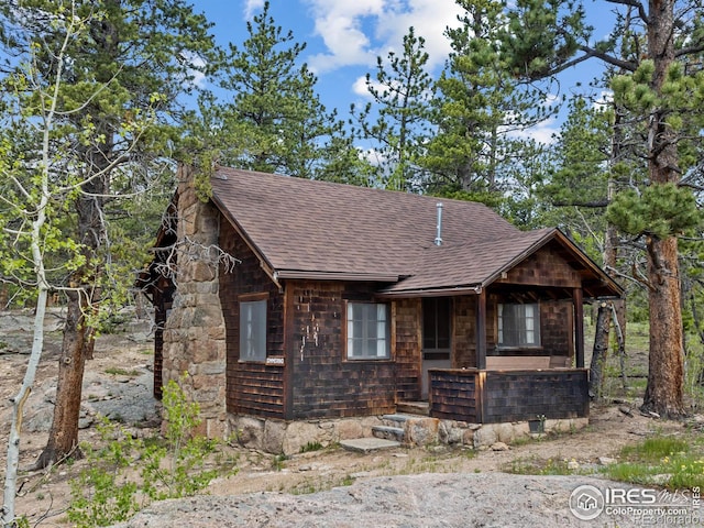 84 County Road 113 N, Allenspark, CO 80510 - chalet / cabin with roof with shingles, covered porch, and a chimney