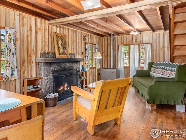 84 County Road 113 N, Allenspark, CO 80510 - living room featuring wooden walls, hardwood / wood-style floors, a stone fireplace, and a wood ceiling with exposed beams