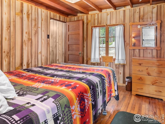84 County Road 113 N, Allenspark, CO 80510 - bedroom with wood walls, wood-type flooring, and beamed ceiling