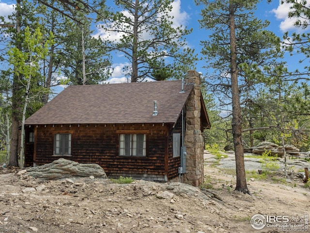 84 County Road 113 N, Allenspark, CO 80510 - view of side of property with a shingled roof and a chimney