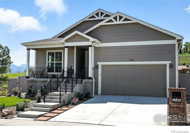 1101 Hillside Ln, Louisville, CO 80027 - view of front facade with covered porch, driveway, a garage, and a mountain view