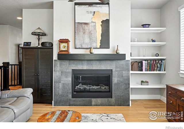 1101 Hillside Ln, Louisville, CO 80027 - living room featuring wood finished floors, a fireplace, built in shelves, and plenty of natural light