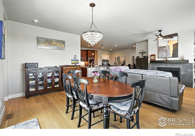 1101 Hillside Ln, Louisville, CO 80027 - dining space featuring light wood-type flooring, a ceiling fan, a chandelier, a fireplace, and recessed lighting