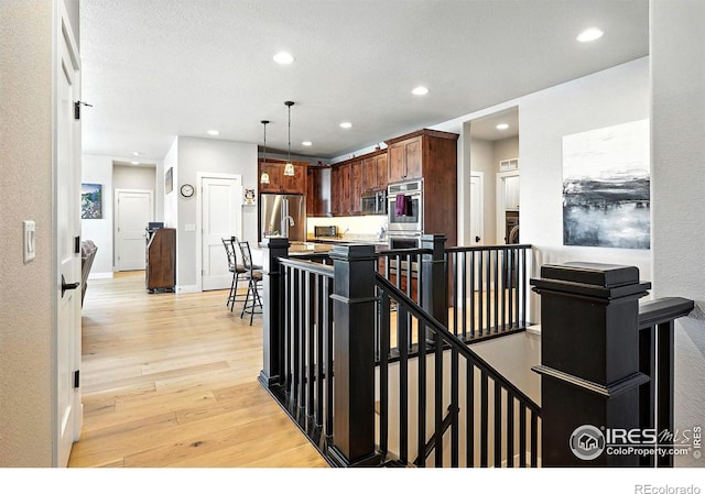 1101 Hillside Ln, Louisville, CO 80027 - kitchen featuring light wood-style floors, appliances with stainless steel finishes, recessed lighting, hanging light fixtures, and light countertops
