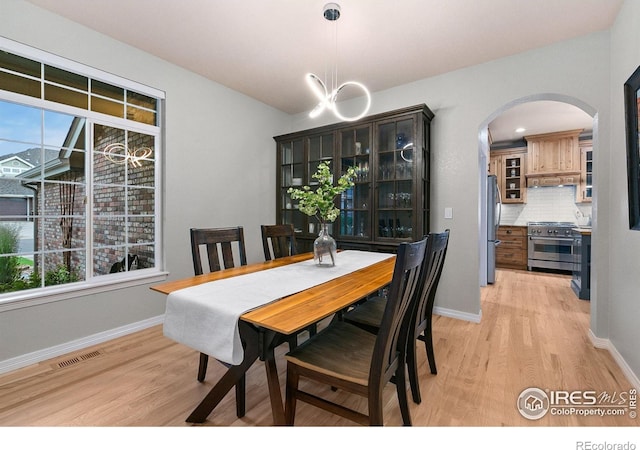 2006 Mackenzie Ct, Fort Collins, CO 80528 - dining area with arched walkways, light wood-style floors, and a chandelier
