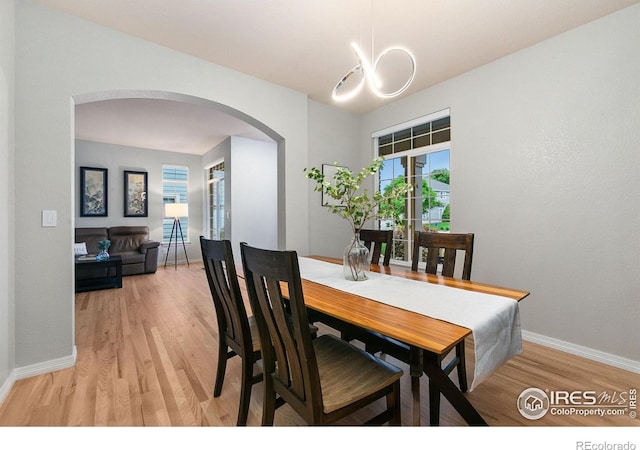 2006 Mackenzie Ct, Fort Collins, CO 80528 - dining area with arched walkways, light wood-type flooring, and a chandelier
