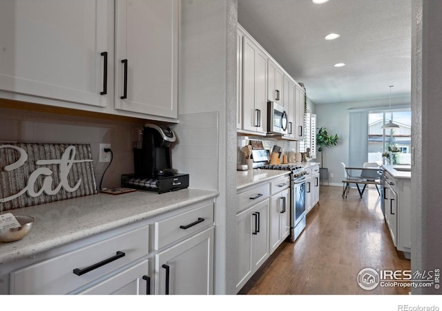 2332 Tabor St, Berthoud, CO 80513 - kitchen featuring stainless steel appliances, backsplash, recessed lighting, white cabinetry, and wood finished floors