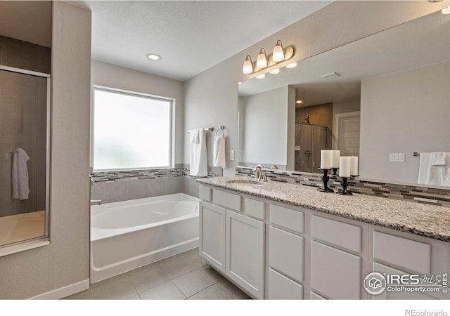 2332 Tabor St, Berthoud, CO 80513 - bathroom with tile patterned floors, a garden tub, a stall shower, vanity, and recessed lighting