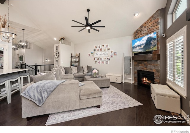 4041 Carroway Seed Dr, Johnstown, CO 80534 - living room with lofted ceiling, a ceiling fan, dark wood-style flooring, a fireplace, and a chandelier