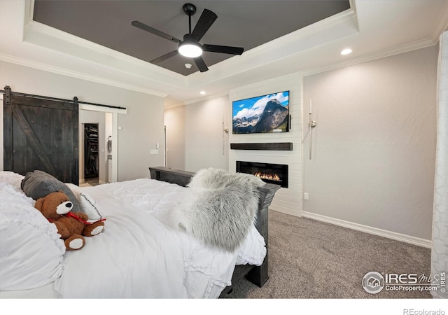 4041 Carroway Seed Dr, Johnstown, CO 80534 - bedroom with a tray ceiling, ornamental molding, carpet flooring, a fireplace, and a barn door