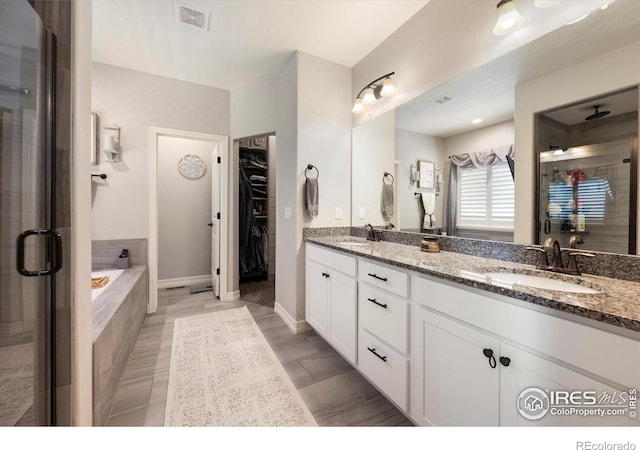 4041 Carroway Seed Dr, Johnstown, CO 80534 - bathroom featuring a shower stall, double vanity, a bath, and a walk in closet