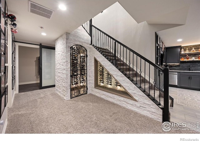 4041 Carroway Seed Dr, Johnstown, CO 80534 - stairs with a barn door, recessed lighting, carpet flooring, and bar