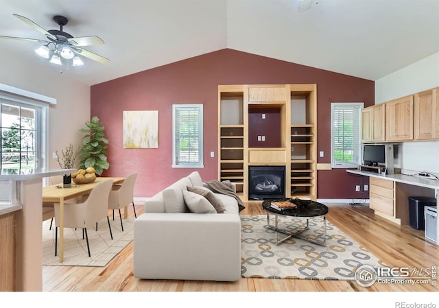6544 Saddleback Ave, Longmont, CO 80504 - living area with light wood-type flooring, lofted ceiling, built in study area, plenty of natural light, and a ceiling fan
