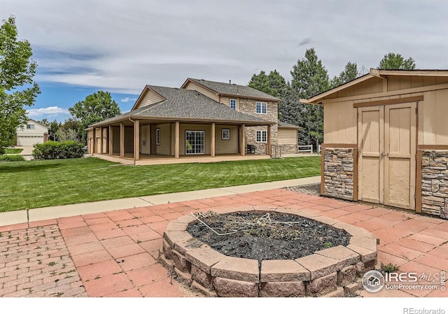 6544 Saddleback Ave, Longmont, CO 80504 - back of property with a fire pit, stone siding, a lawn, a shed, and a porch